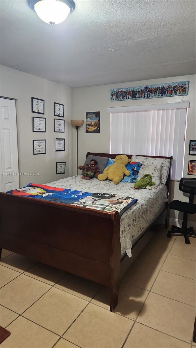 8254 Southwest 147th Place Miami, FL 33193 - Photo 10 of 14 a bedroom with a bed and a chair