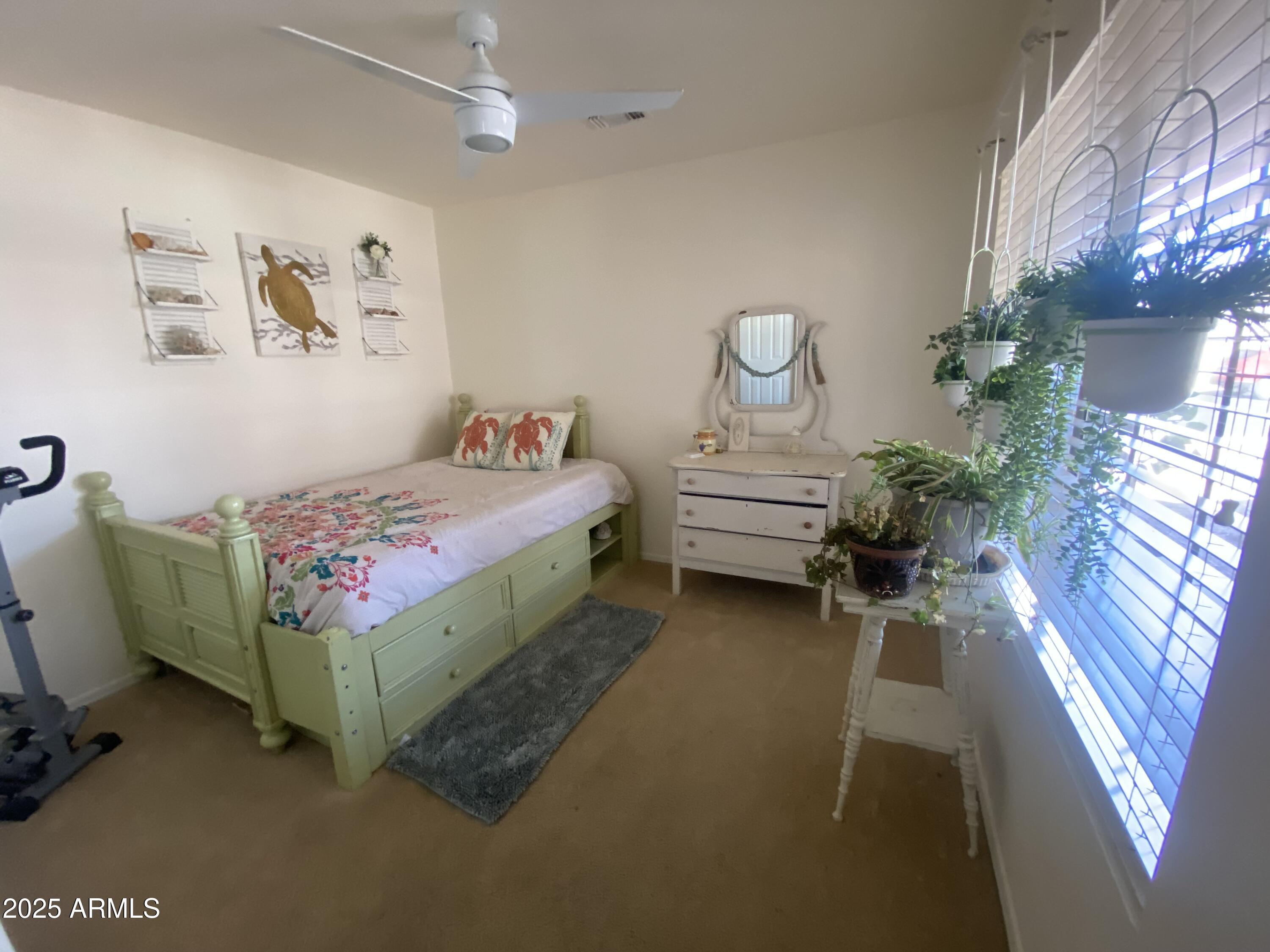 2101 South Meridian Road, Unit 431 Apache Junction, AZ 85120 - Photo 12 of 26 a bedroom with a bed table flowerpot and window