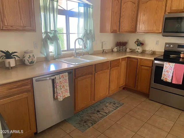 a kitchen with stainless steel appliances granite countertop a sink window and cabinets