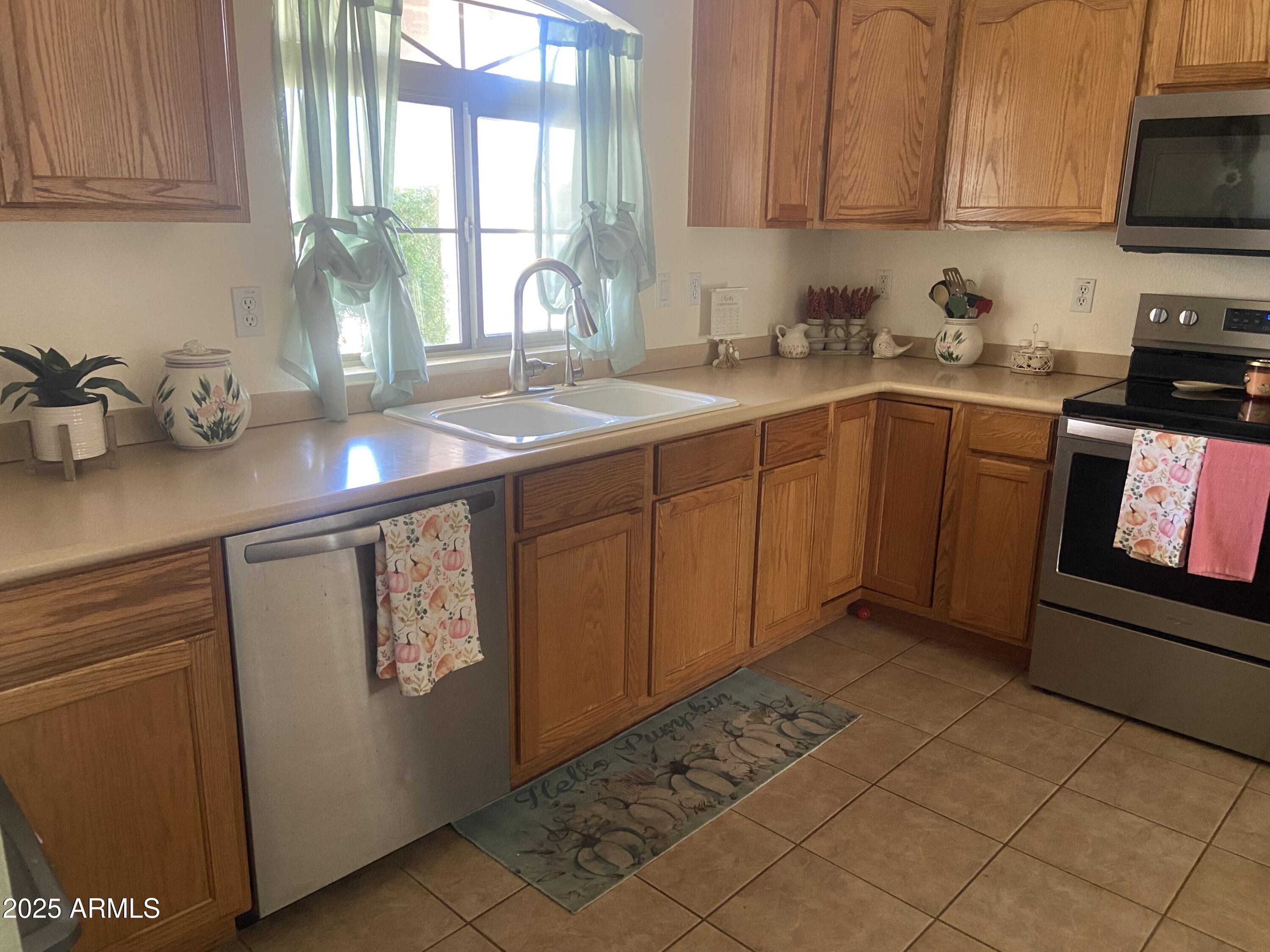 2101 South Meridian Road, Unit 431 Apache Junction, AZ 85120 - Photo 6 of 26 a kitchen with stainless steel appliances granite countertop a sink window and cabinets