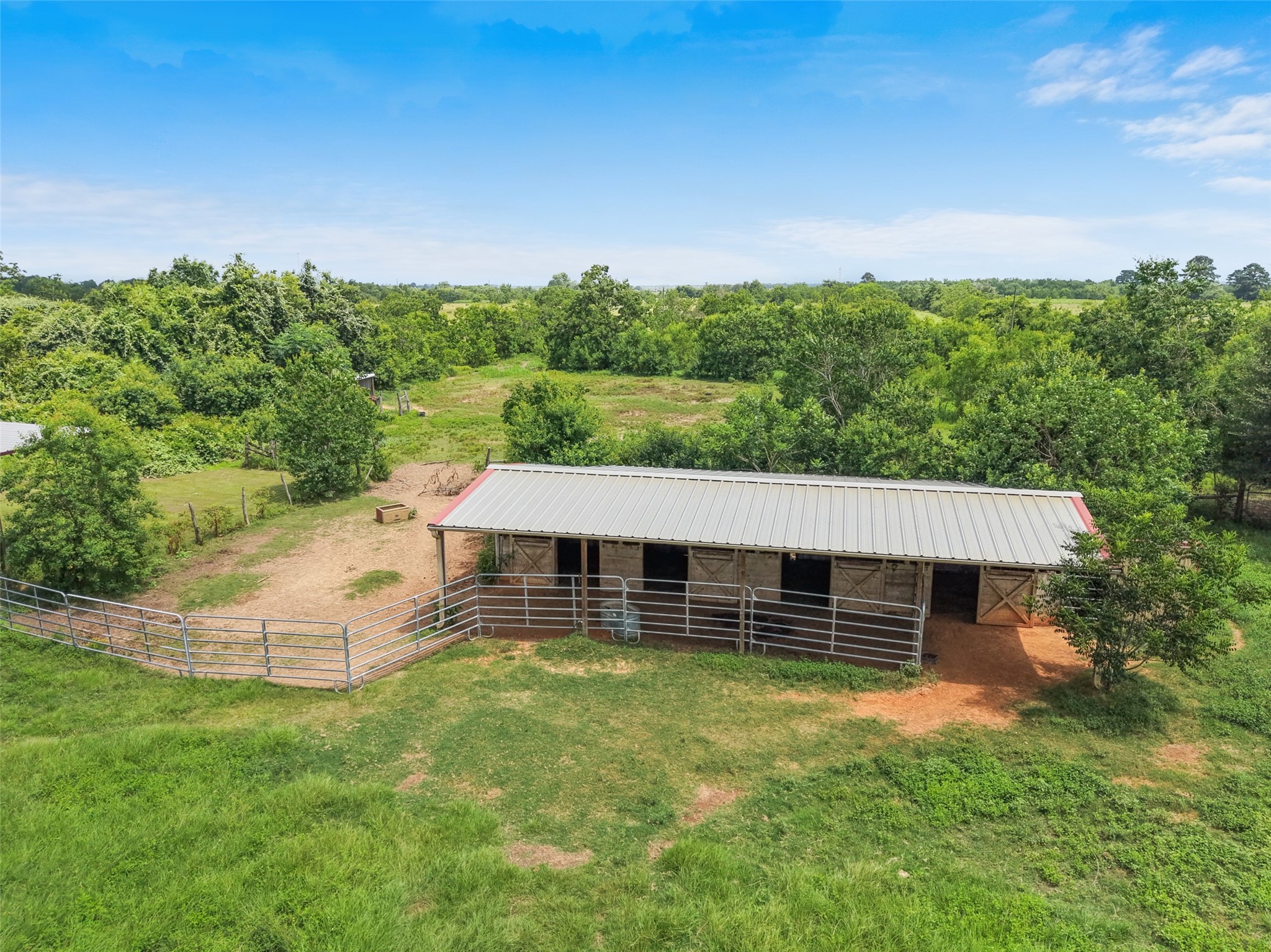 34366 Owens Road Hempstead, TX 77445 - Photo 32 of 46 Versatile barn with multiple stalls and covered space, ideal for livestock, equipment storage, workshop use, or a variety of agricultural and hobby farm needs