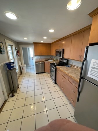 233 Appleton Street Lowell, MA 01852 - Photo 6 of 6 a kitchen with stainless steel appliances a sink a stove top oven a counter space and cabinets