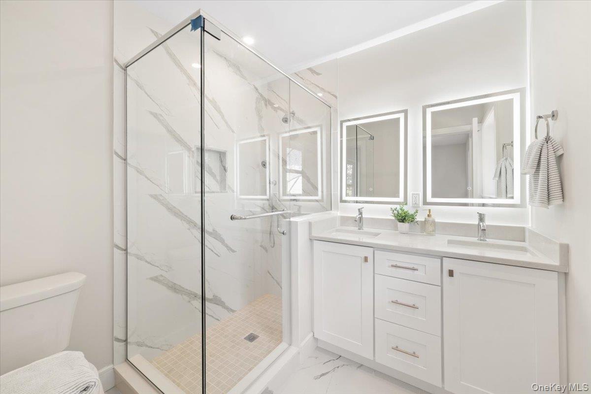 395 5th Avenue New Rochelle, NY 10801 - Photo 14 of 26 a bathroom with a granite countertop sink a mirror and a shower