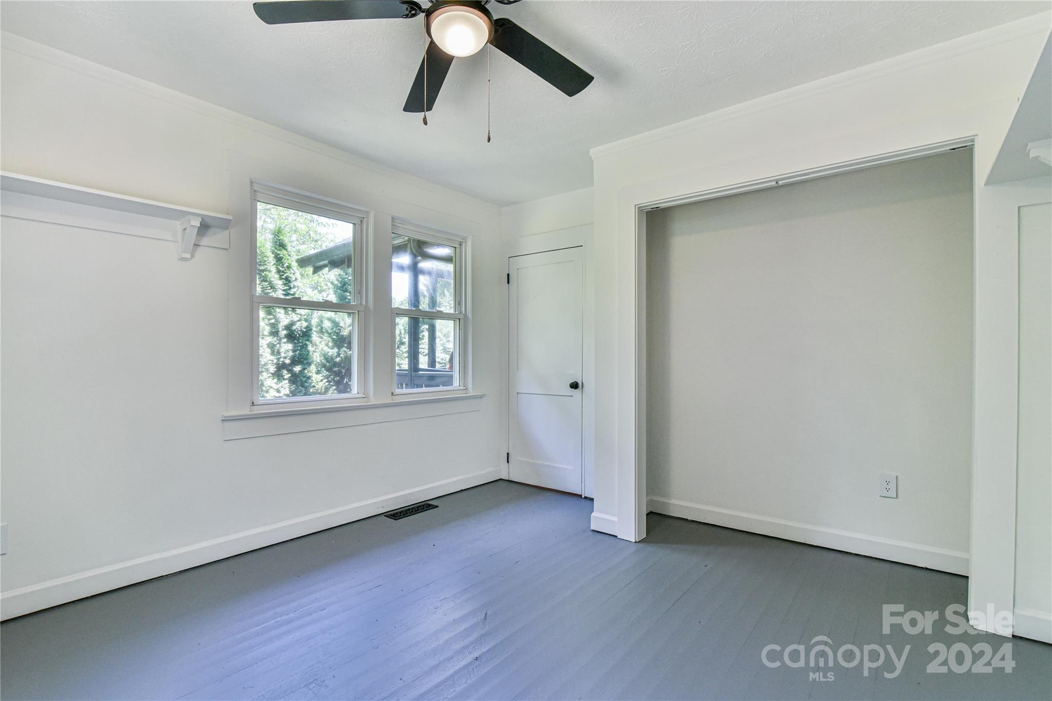 210 East Oakview Road Asheville, NC 28806 - Photo 17 of 31 a view of an empty room with wooden floor and a window
