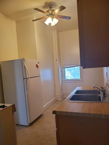 a room with a refrigerator and a chandelier