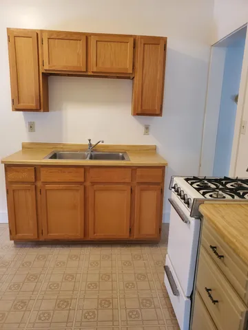 a kitchen with stainless steel appliances a stove a sink and a refrigerator