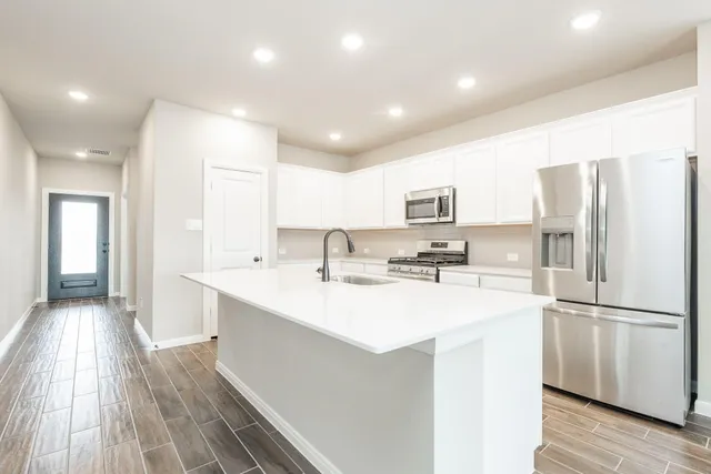 a kitchen with stainless steel appliances a refrigerator sink and microwave
