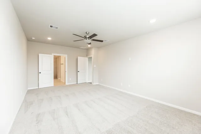 a view of an empty room with a chandelier fan