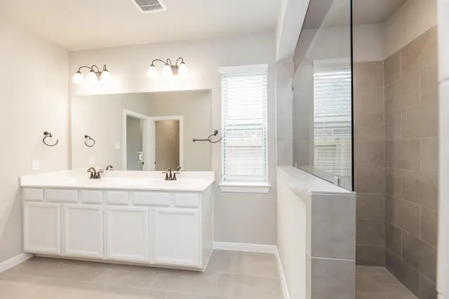 a bathroom with a double vanity sink mirror and next to a window