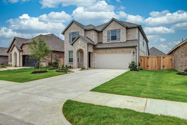 a front view of a house with a garden and yard