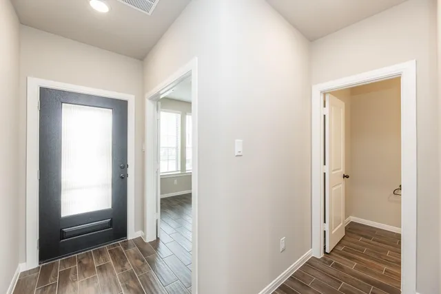a view of a room with wooden floor and a bathroom