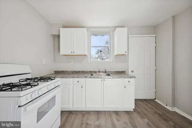 a kitchen with granite countertop a sink and a stove