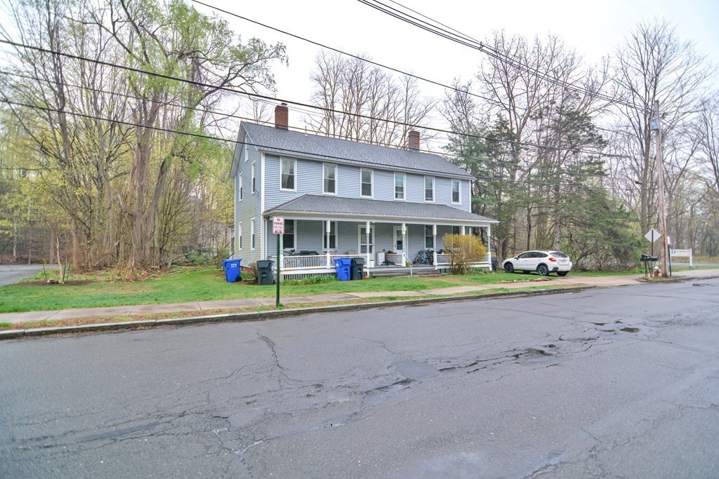 183 Main Street Northampton, MA 01053 - Photo 3 of 42 a view of a brick house with a big yard and large trees