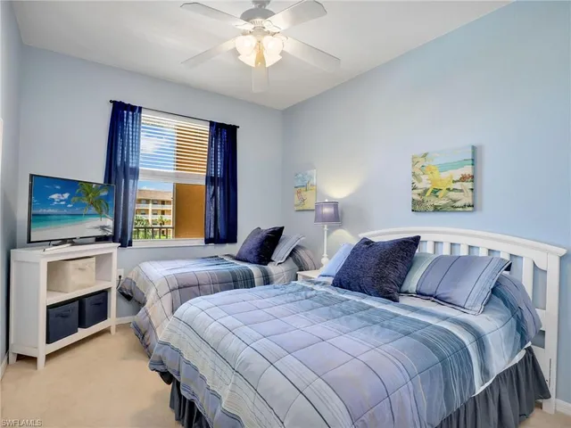 a bedroom with two bed and a flat screen tv