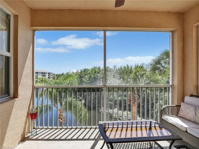 a balcony with wooden floor table and chairs
