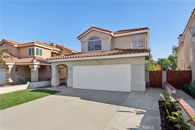 a front view of a house with a garden and plants
