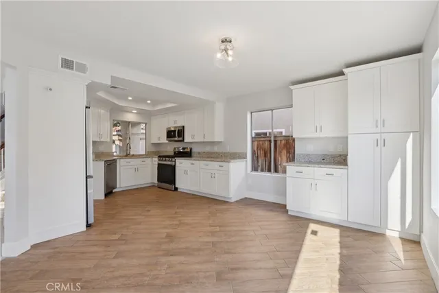 a kitchen with white cabinets and stainless steel appliances