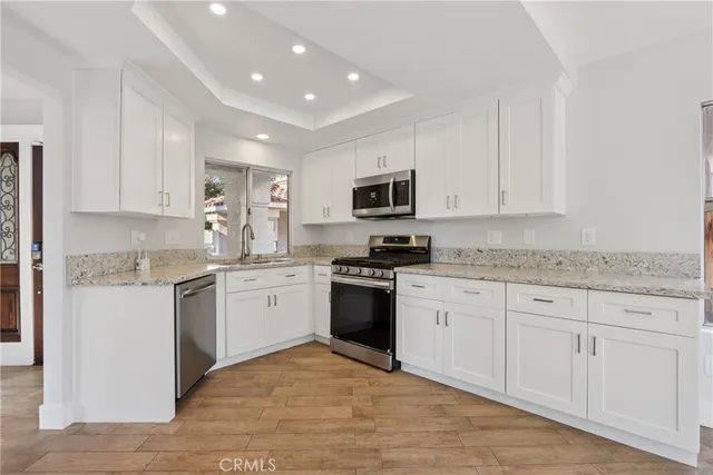 a kitchen with granite countertop white cabinets and white appliances