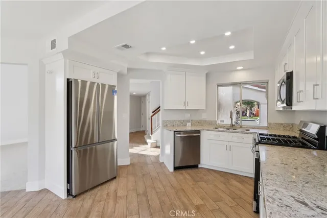 a kitchen with granite countertop a refrigerator stove top oven and sink