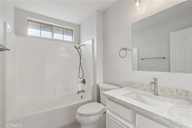 a bathroom with a granite countertop sink a toilet and a bathtub
