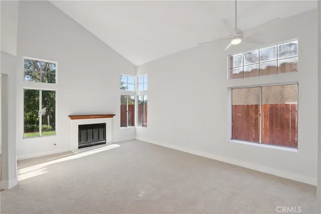 an empty room with windows and fireplace