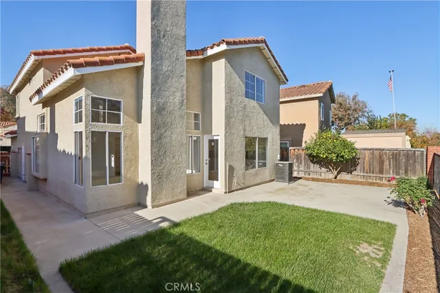 a front view of a house with a yard and potted plants