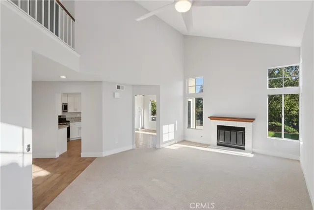 a view of an empty room with a fireplace and a window