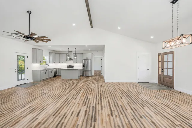 a view of a room with a kitchen and wooden floor