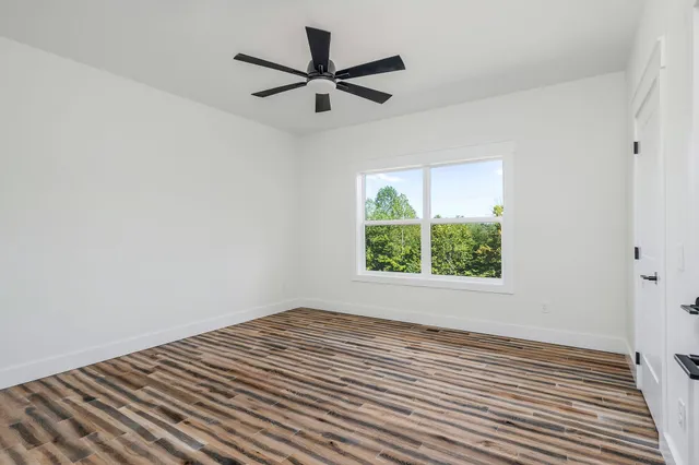 a view of a room with wooden floor and windows
