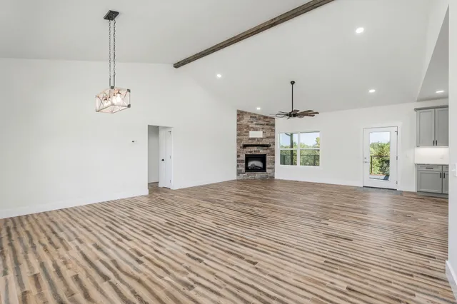 a view of a room with wooden floor fireplace and window
