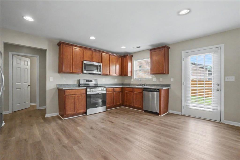 375 Walton View Fairburn, GA 30213 - Photo 15 of 38 a kitchen with stainless steel appliances granite countertop a stove a sink dishwasher a refrigerator and a microwave oven with wooden floor