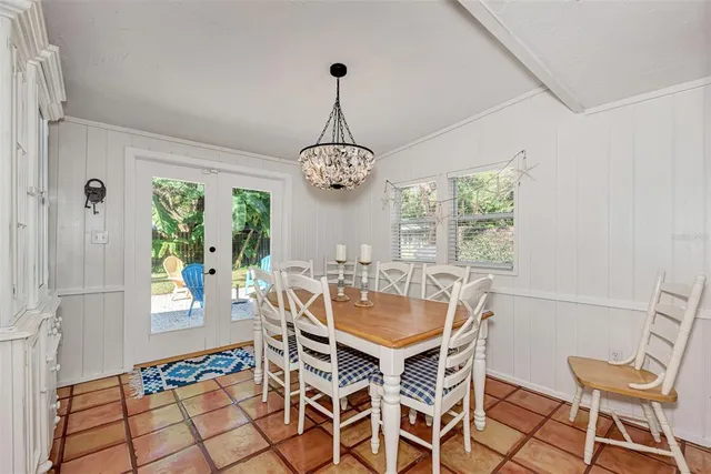 a dining room with chandelier fan and wooden floor