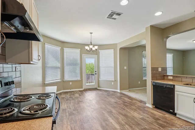 a kitchen with white cabinets and appliances