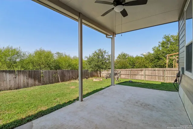 a view of backyard with wooden fence