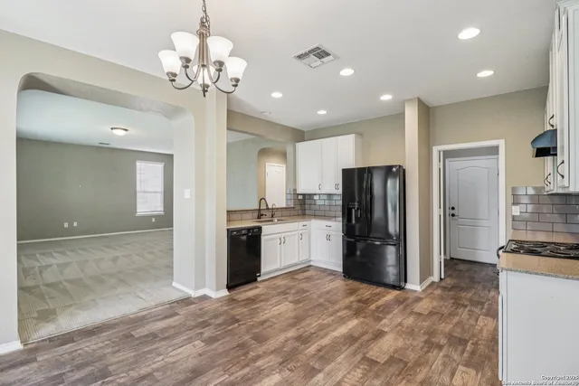a kitchen with a stove and white cabinets