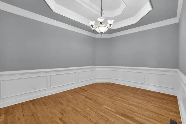 a view of a room with wooden floor and chandelier