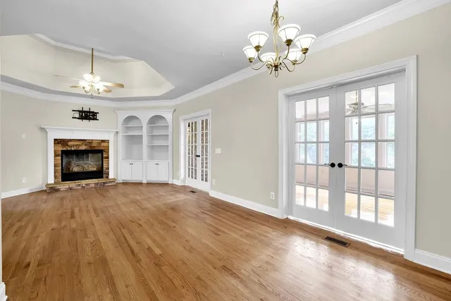 a view of an empty room with a fireplace and a window