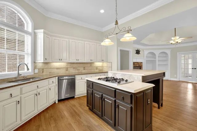 a kitchen with stove a sink and cabinets