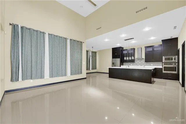 a large white kitchen with a refrigerator a counter top space and cabinets