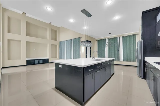 a kitchen with stainless steel appliances granite countertop a sink and a refrigerator