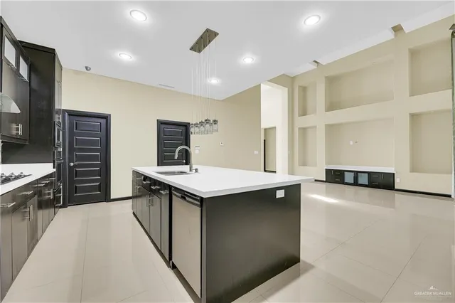 a kitchen with stainless steel appliances granite countertop a sink and a stove top oven with wooden floor