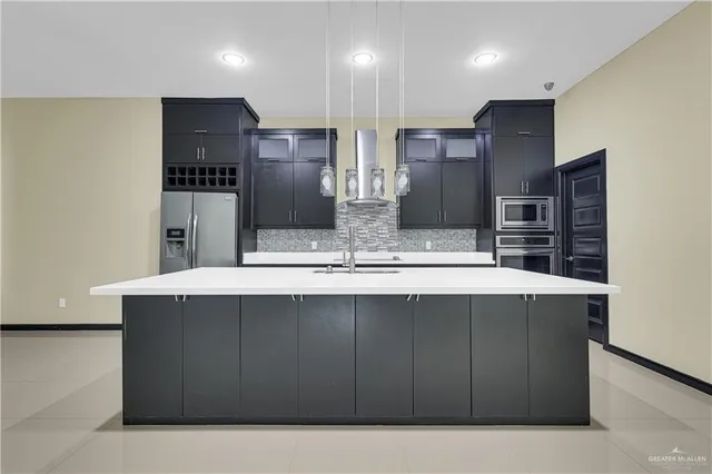 a kitchen with stainless steel appliances a sink and a refrigerator
