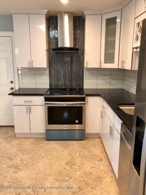 9 Swan Road, Unit 1000 Howell, NJ 07731 - Photo 1 of 13 a kitchen with granite countertop a stove and a sink