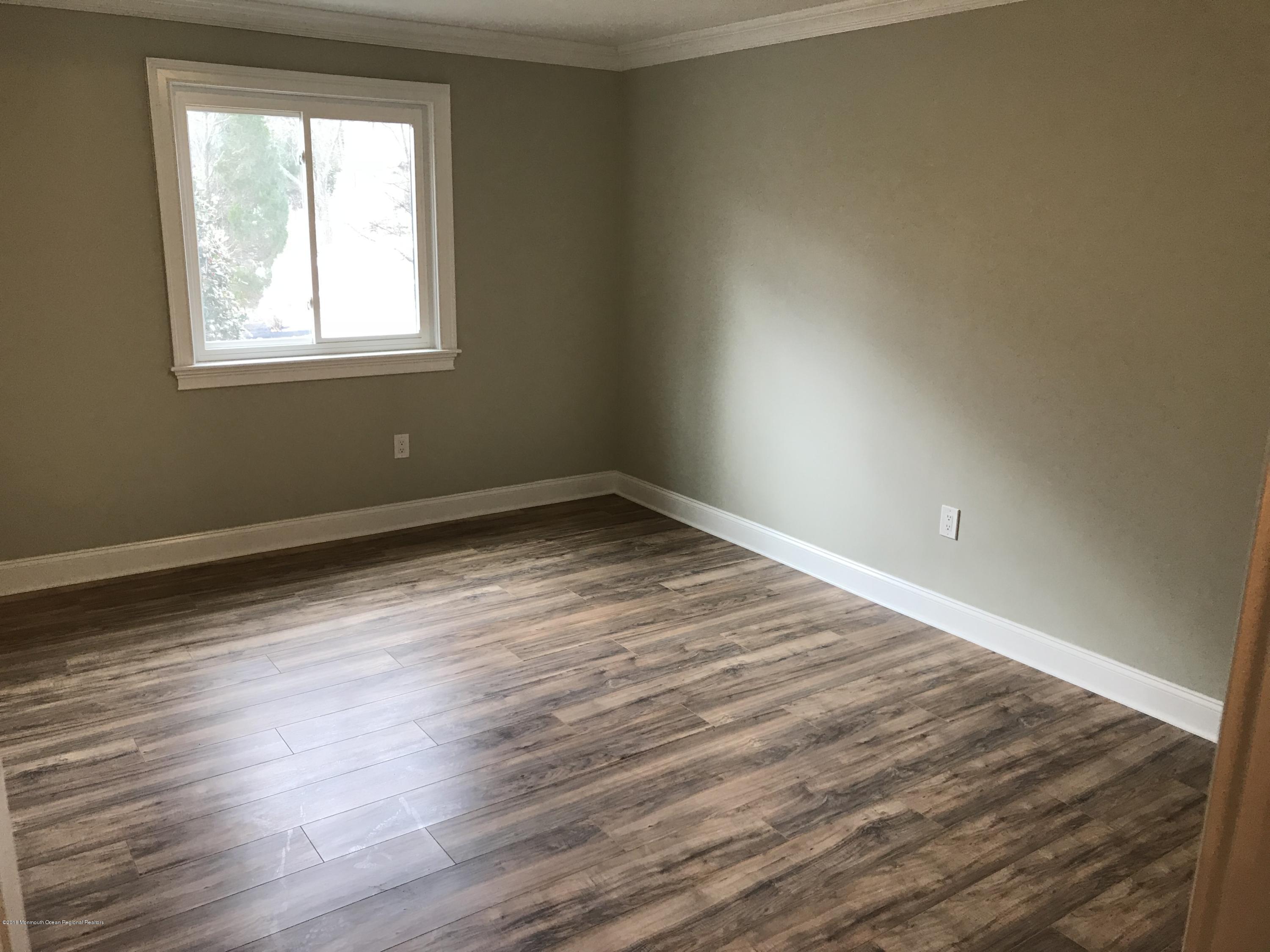 9 Swan Road, Unit 1000 Howell, NJ 07731 - Photo 8 of 13 an empty room with wooden floor and windows