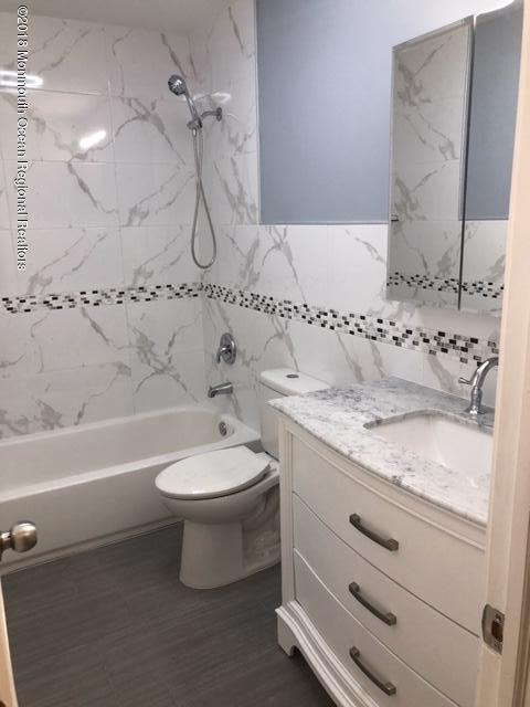 9 Swan Road, Unit 1000 Howell, NJ 07731 - Photo 9 of 13 a bathroom with a granite countertop toilet a sink and bathtub