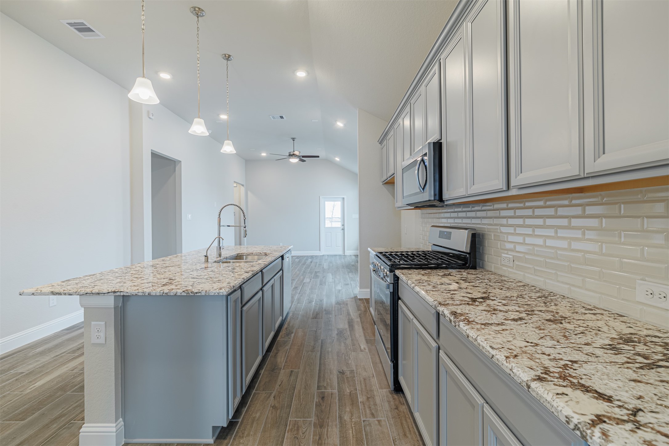 12611 White Pelican Court Cypress, TX 77433 - Photo 7 of 24 a kitchen with stainless steel appliances granite countertop a sink stove and cabinets