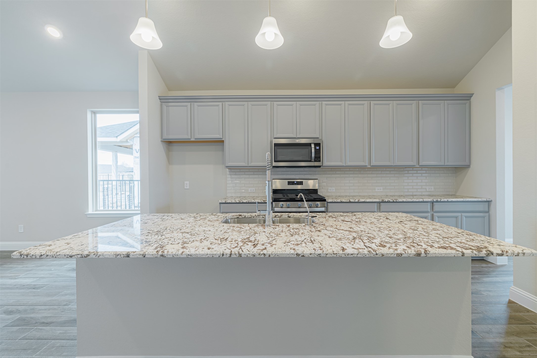12611 White Pelican Court Cypress, TX 77433 - Photo 9 of 24 a kitchen with kitchen island granite countertop a sink cabinets and stainless steel appliances