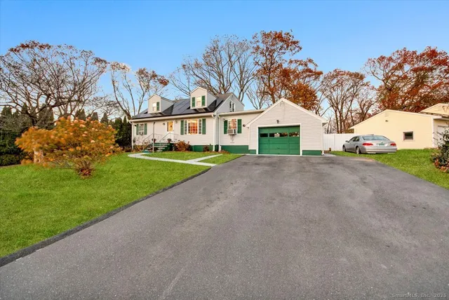 a view of house with a yard and potted plants