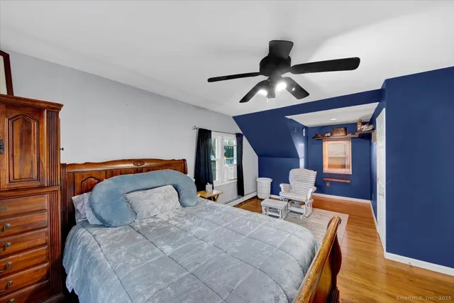 a bedroom with bed and wooden floor