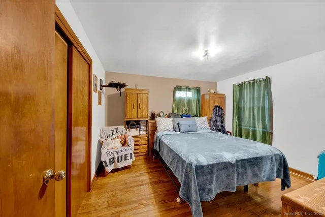 a view of a bedroom with a bed and wooden floor